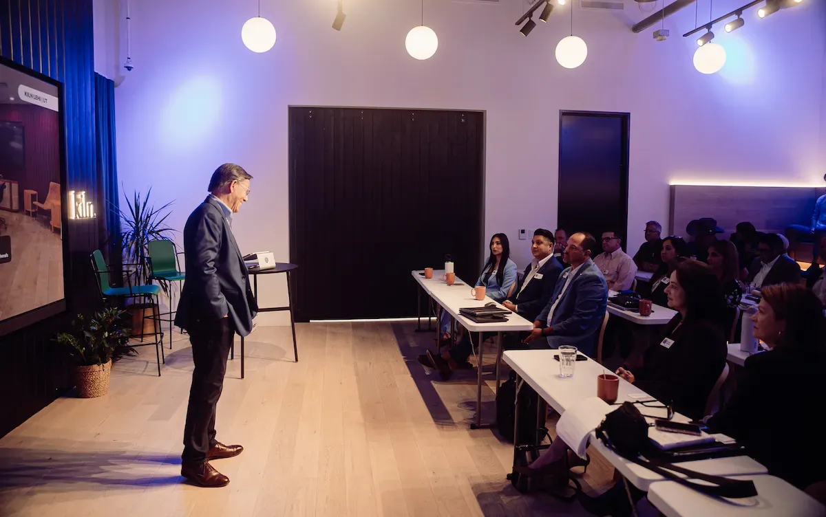 John Franklin Wiley standing before a full room at Kiln